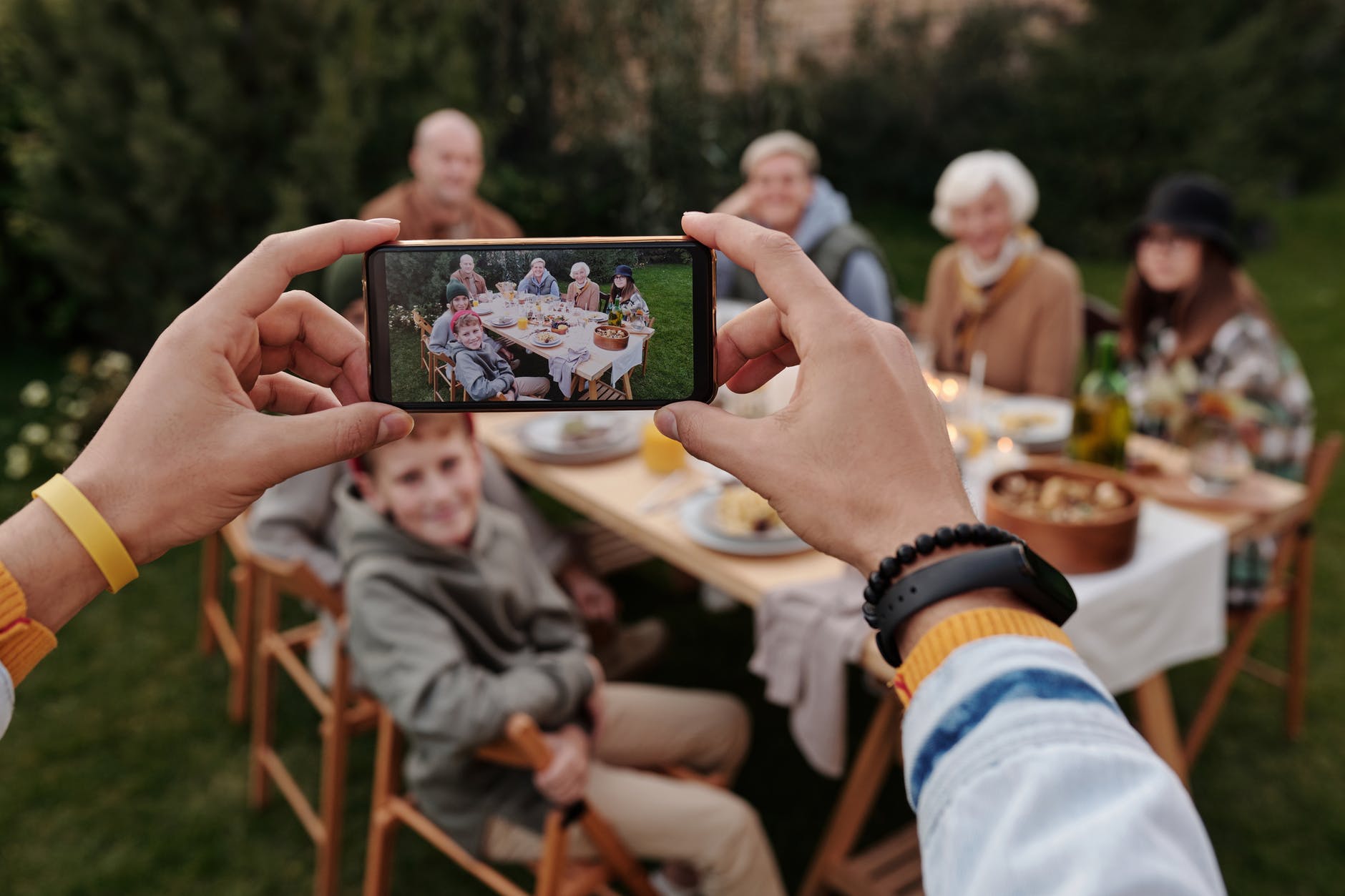 Someone is taking a picture of a family gathering using a cell phone.